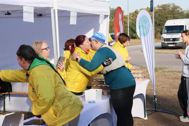 Szervezők sárga mellényben osztják a rajtszámokat a sátorban