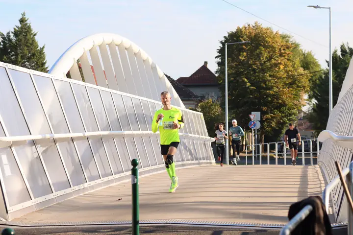 Neonzöld pólós futó a Török utcai vasúti hídon