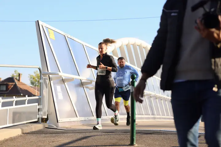 Futók a hídon, előtérben egy szurkoló