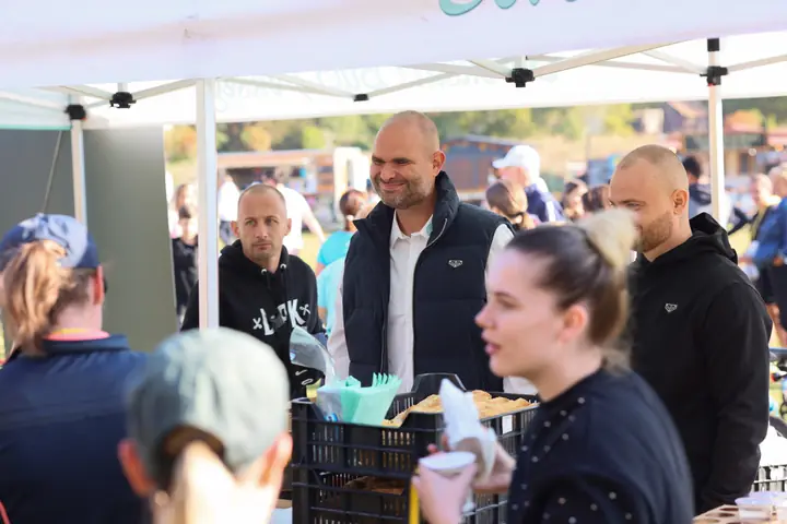 Célba ért futók a Buci Pékség sátránál, a pékség munkatársai osztanak