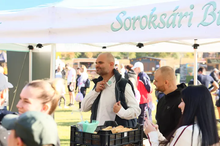 Mosolygó pékségi munkatárs a sátorban a futók között