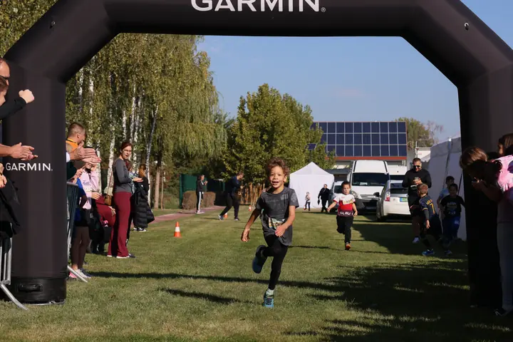 Gyerek fut be a Garmin célkapun át a füves pályán