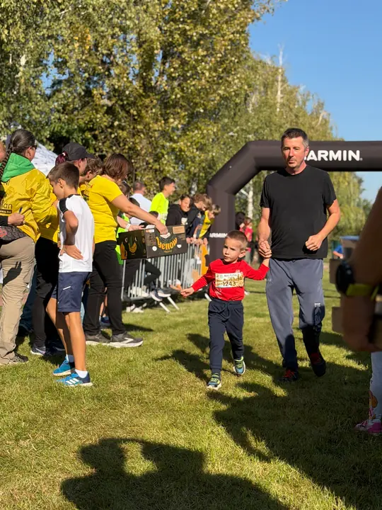 Kisfiú apjával fut a gyerekfutam célja felé