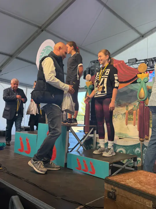 Díjátadás a színpadon egy dobogós futónak